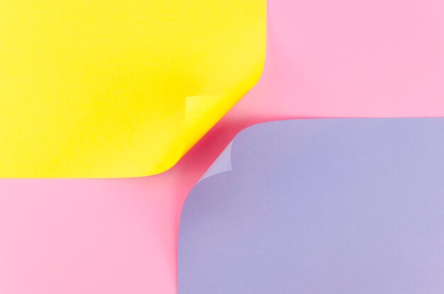 Flat lay of two colorful paper sheets with bent corners