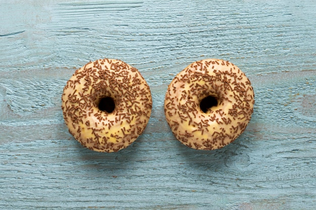 Free photo flat lay of two doughnuts on wooden surface