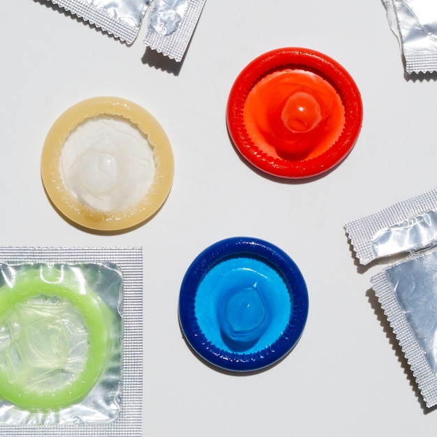 Бесплатное фото Плоские лежал развернутые презервативы на белом фоне