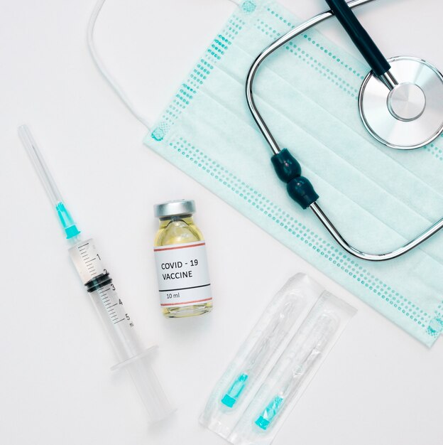 Flat lay of vaccine with syringe and stethoscope