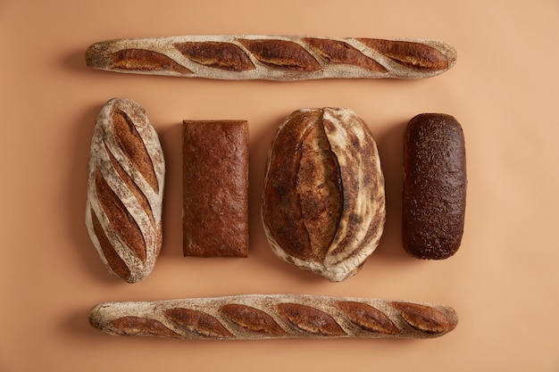 Flat lay of various bread kinds baguette, buckwheat bread, rye with cumin, made on sourdough. Buy local fresh baked products in bakers shop. Healthy eating concept. Delicious bakery for sale