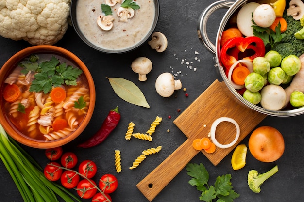 Flat lay vegetables in pan with vegetable soup with fusilli