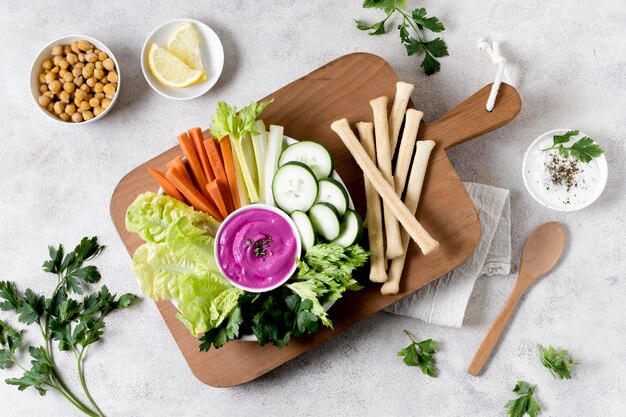 Flat lay of vegetables with chickpeas on chopping board