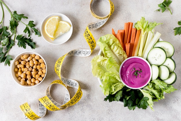 Free photo flat lay of vegetables with chickpeas and measuring tape