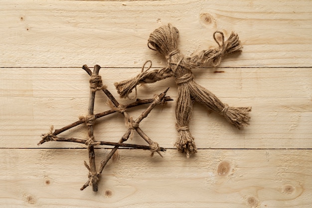 Flat lay voodoo doll on wooden background