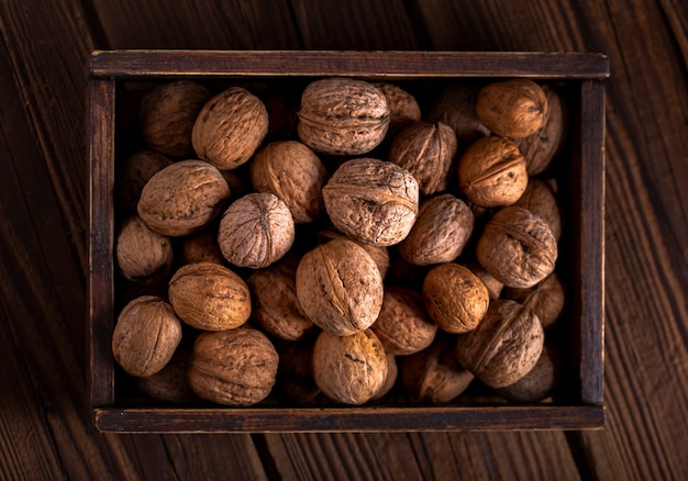 Free photo flat lay walnuts in wooden box