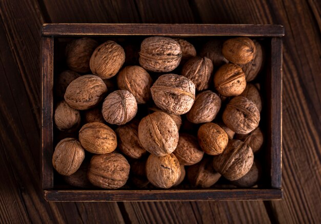 Плоские лежал грецкие орехи в деревянной коробке