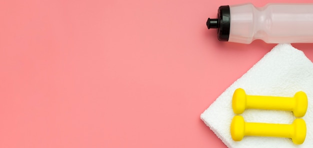 Flat lay of water bottle with weights and towel