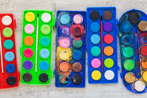 Flat lay watercolor paint in colored containers