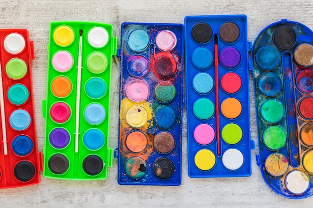 Flat lay watercolor paint in colored containers