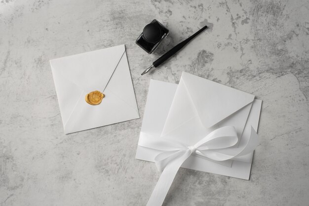 flat lay of wedding paper and envelope with ink and pen