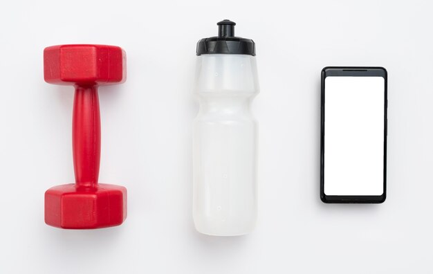 Flat lay of weight with water bottle and smartphone