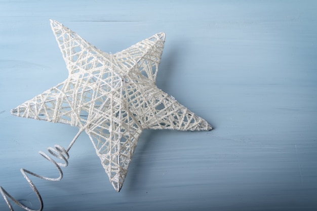 Плоская планировка белой елочной игрушки в виде звезды на деревянном фоне
