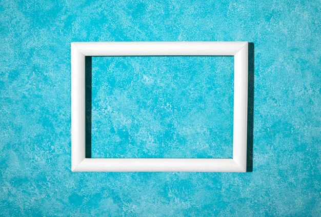 Flat lay white frame on blue background