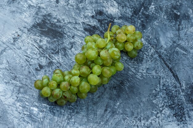 Flat lay white grapes on dark blue marble background. horizontal