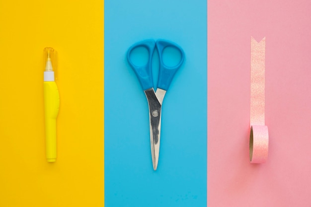 Flat lay of white-out pen with tape and scissors