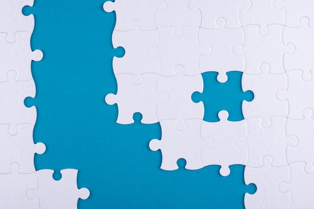 Flat lay white puzzle pieces and blue background