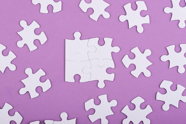 Flat lay white puzzle pieces and purple background