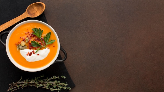 Flat lay of winter squash soup in bowl with parsley and copy space