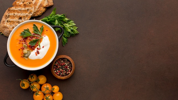 Flat lay of winter squash soup in bowl with toast and copy space