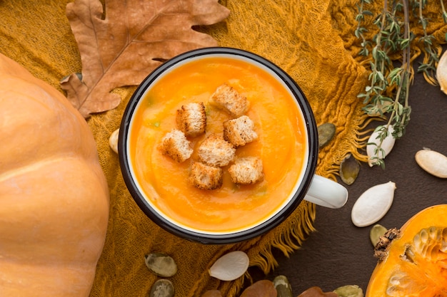 Lay piatto di zuppa di zucca invernale in tazza con crostini di pane