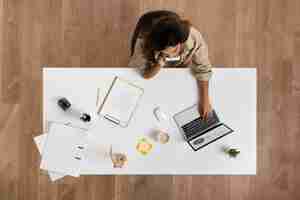 Free photo flat lay woman working at desk