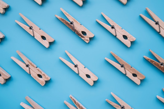 Flat lay wooden clothespins on blue background