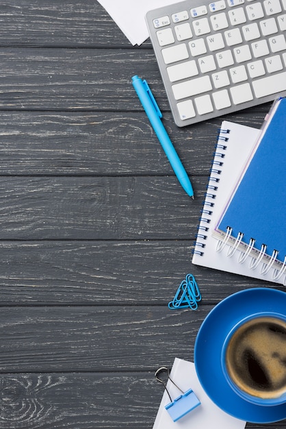 Free photo flat lay of wooden desk with coffee cup and keyboard