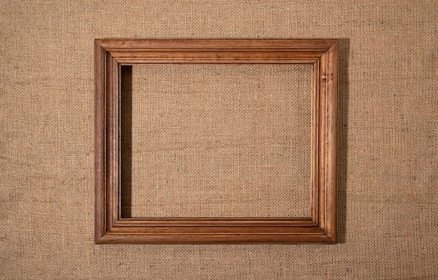 Flat lay wooden frame on textured material