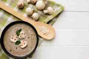 Foto gratuita cucchiaio di legno piatto e bisque di funghi con funghi