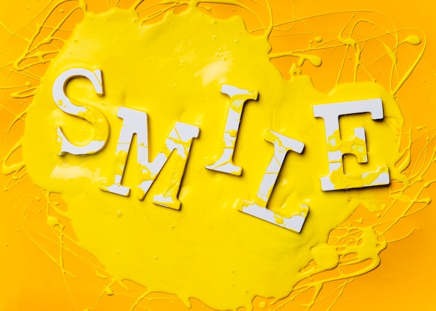 Free photo flat lay of word smile with paint