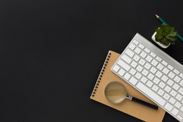 Flat lay of work desktop with notebook and keyboard