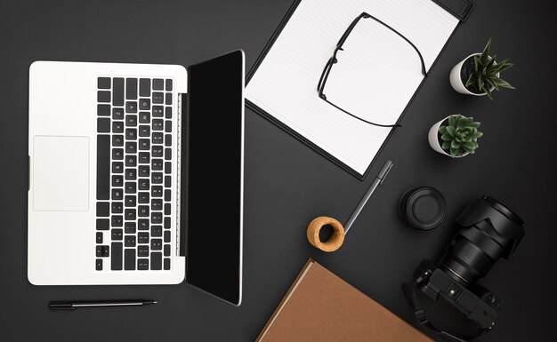 Flat lay of workstation with laptop and camera