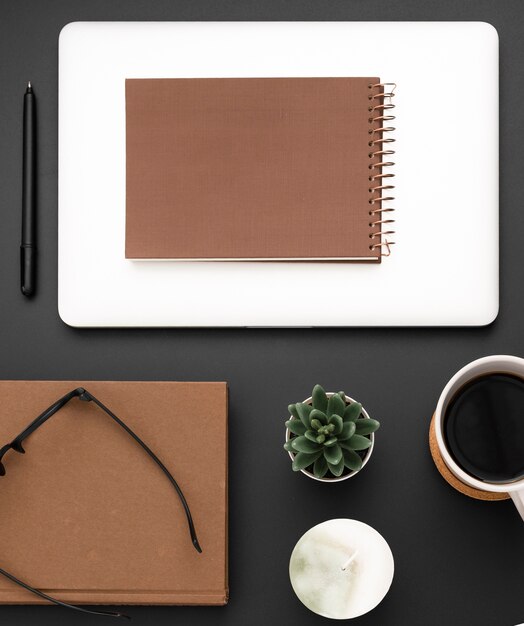 Flat lay of workstation with notebook and glasses on top of agenda