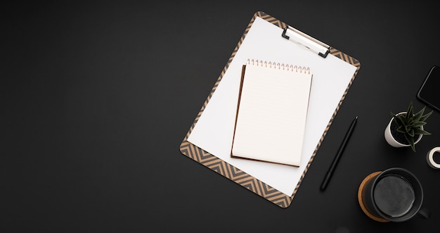 Flat lay of workstation with notepad and succulent plant