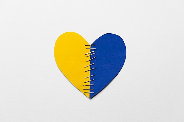 Flat lay yellow and blue heart with stitches