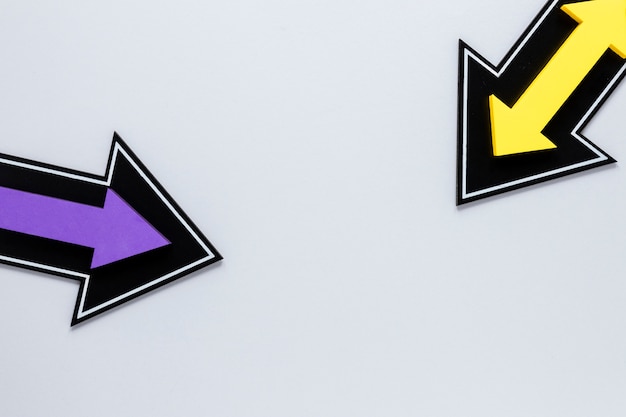 白い背景の上のフラットレイアウト黄色と紫の矢印