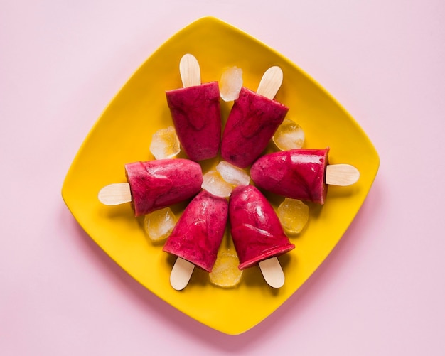 Free photo flat lay of yummy popsicles on plate with ice