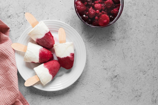 Free photo flat lay of yummy popsicles with berries mix