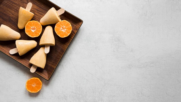 Flat lay of yummy popsicles with copy space and fruit