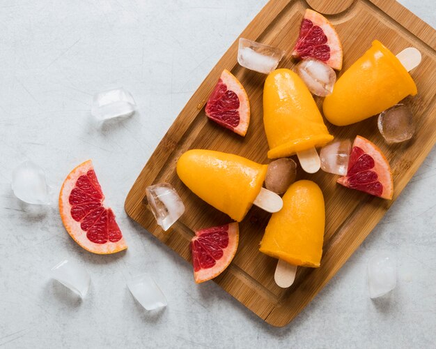 Flat lay of yummy red grapefruit flavored popsicles