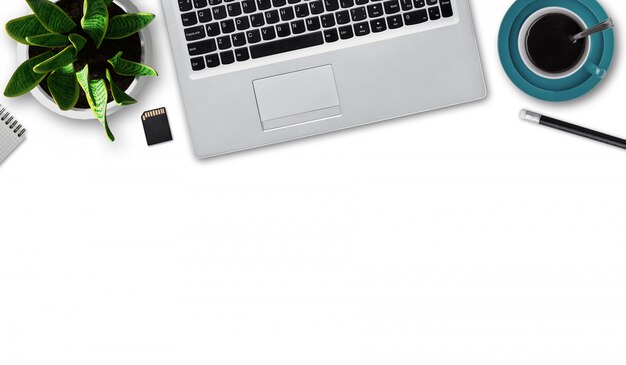 Flat layout of modern laptop, cup of coffee, pencil, notepad, flash card, flowerpot with green plant isolated over white wall with copy space. Modern gadget. Workplace of businessman