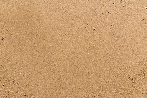 ビーチの織り目加工の背景に平らな砂