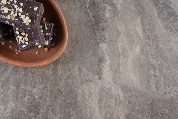 Ароматные шоколадные вафли на глиняной миске на мраморе.
