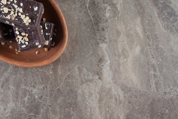 Flavorful chocolate waffle on a clay bowl on marble.