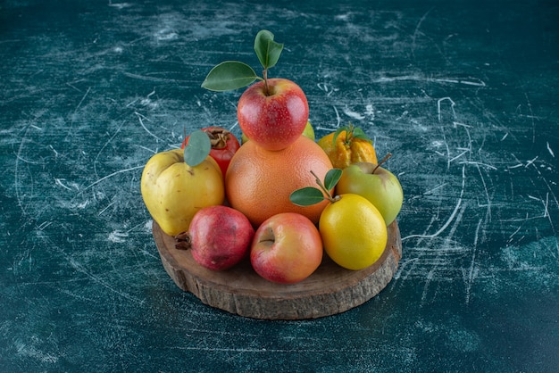 Flavorful fruits on the board, on the blue background. High quality photo