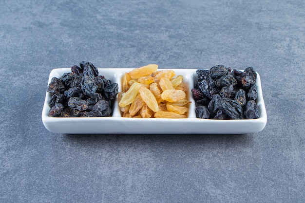 Flavorful raisins on a dish on the marble surface