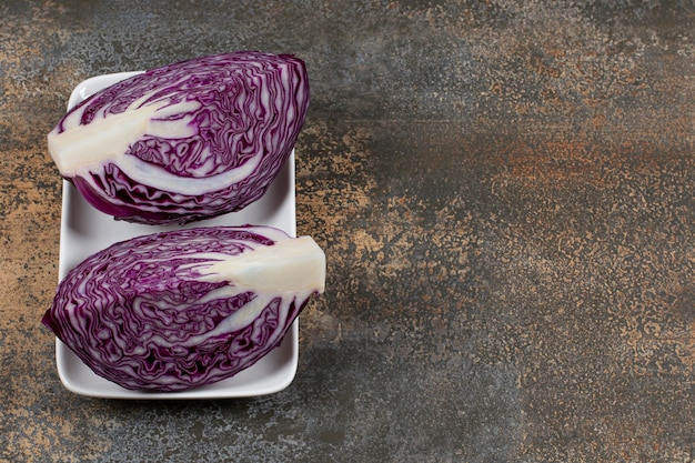 Flavorful red cabbage in the white plate on the marble surface