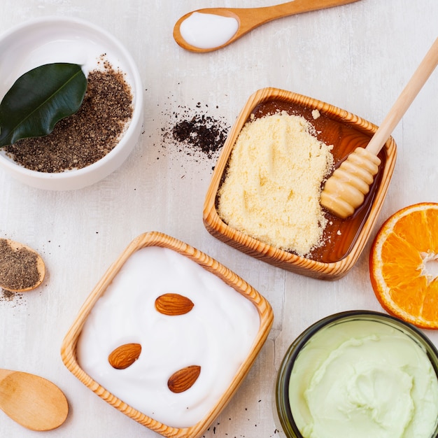 Flay lay of body butter with almonds on wooden table