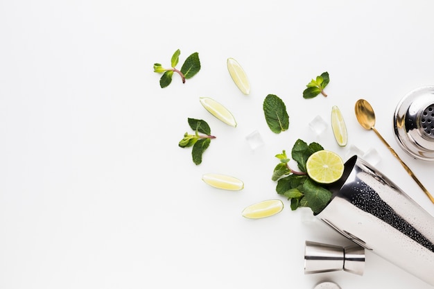 Flay lay of cocktail essentials with lime slices and mint